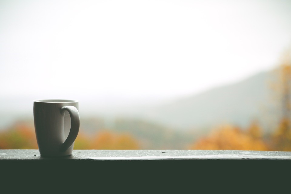 coffee cup on a porch railing